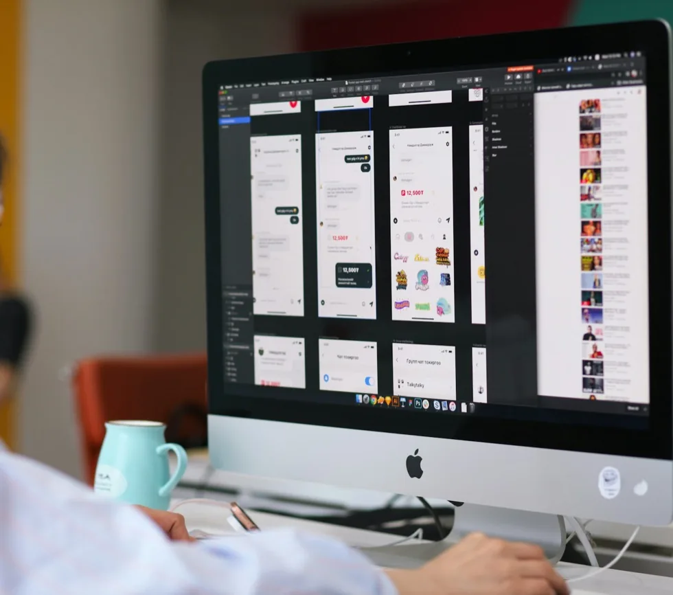 App screens laid out on an artboard in a design tool, seen over someone's shoulder.